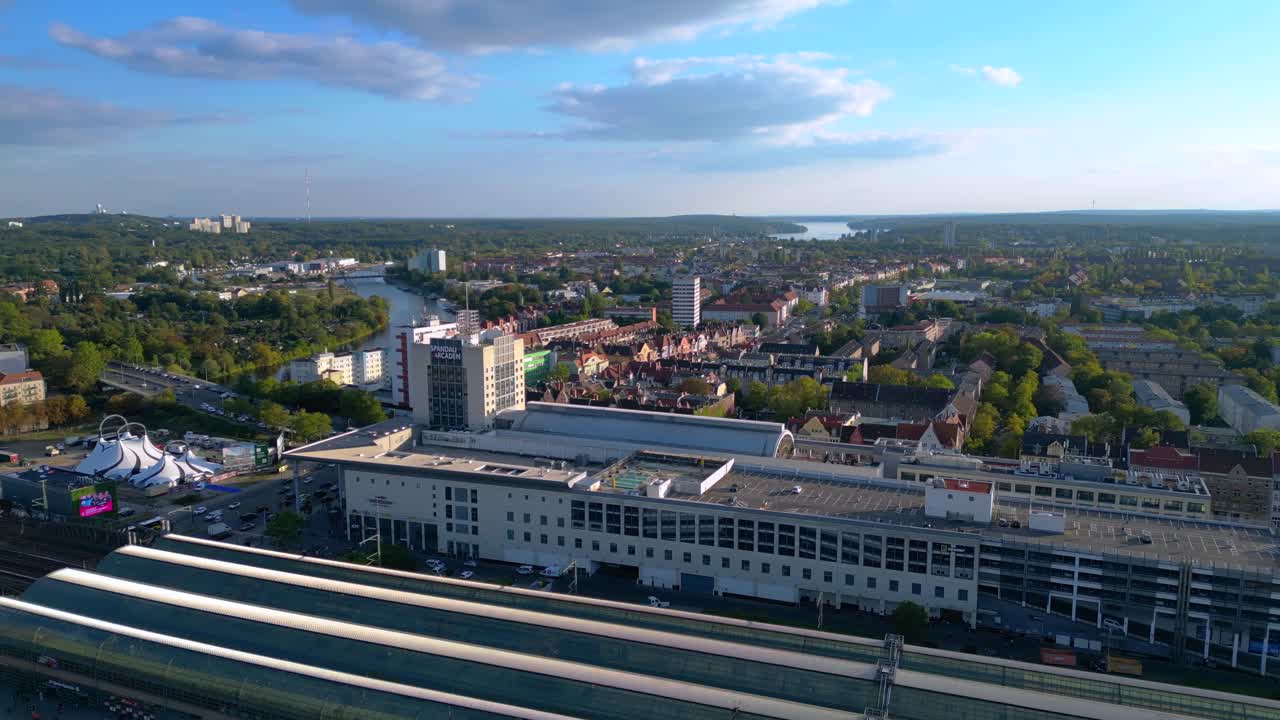 Berlin Spandau train station and Mall shopping center with surrounding urban landscape. Nice aerial view flight rotation pan to right drone