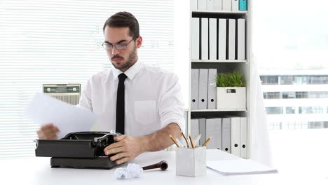 hombre de negocios trabajando en la máquina de escribir en su escritorio