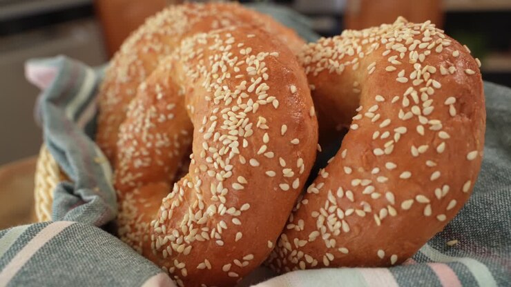 Freshly Baked Round Bagels with Sesame Seeds on Towel in Close Up