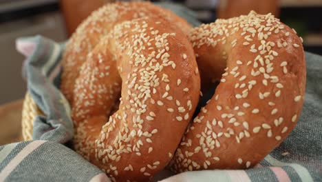 freshly baked round bagels with sesame seeds on towel in close up