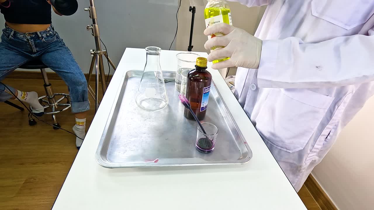 A scientist conducts a vibrant chemical reaction using beakers, tubes, and food coloring on a lab table