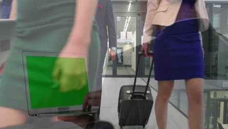 animación de un hombre de negocios usando una computadora portátil con pantalla verde sobre colegas felices caminando con equipaje