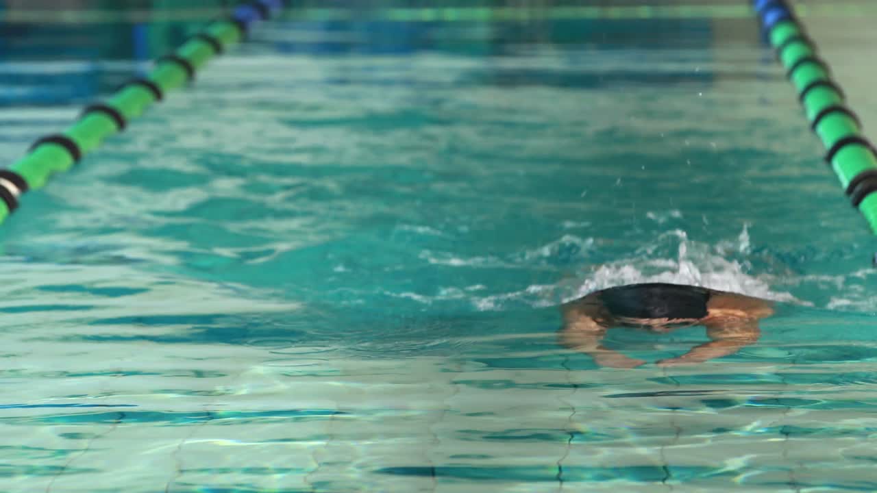 수영장에서 나비 스트로크를 하는 적합한 수영 선수