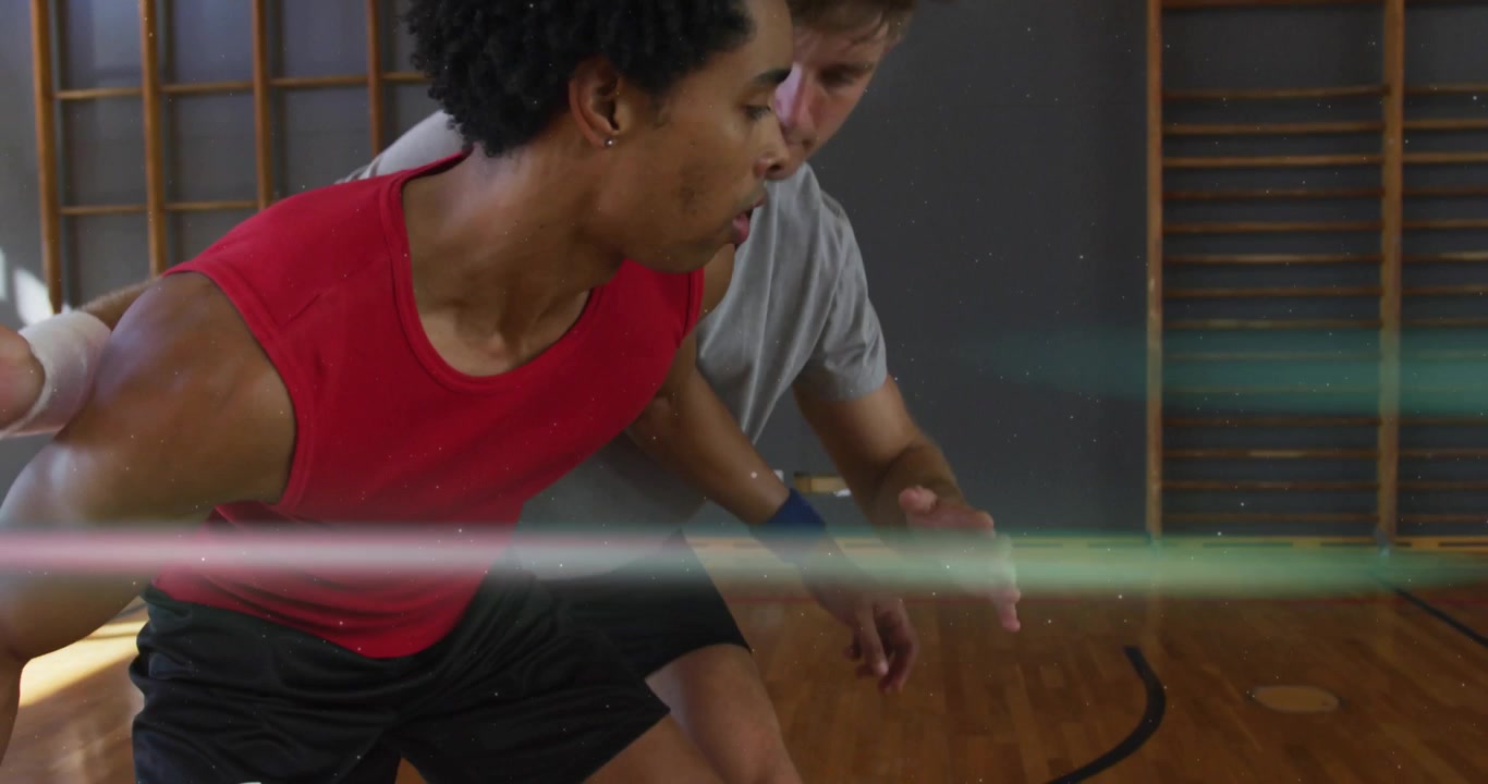 Red jersey player initiating basketball crossover dribbling in gym and beating defender for swish