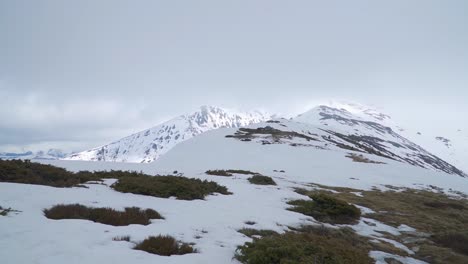 las laderas cubiertas de hierba se convierten en picos montañosos cubiertos de nieve en la distancia