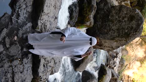 vertical shot of a person doing a social media trend dressed as a ghost at a river