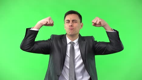 well dressed man in suit raising fists and showing muscles