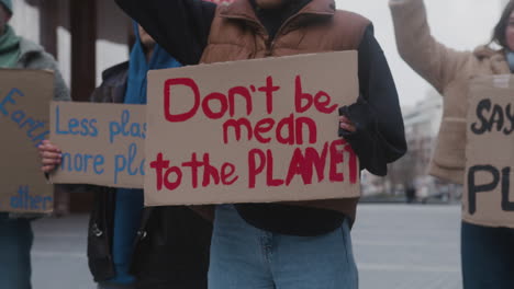 group of young activists with banners protesting against climate change to save the earth