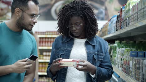 happy young couple making purchases in grocery store