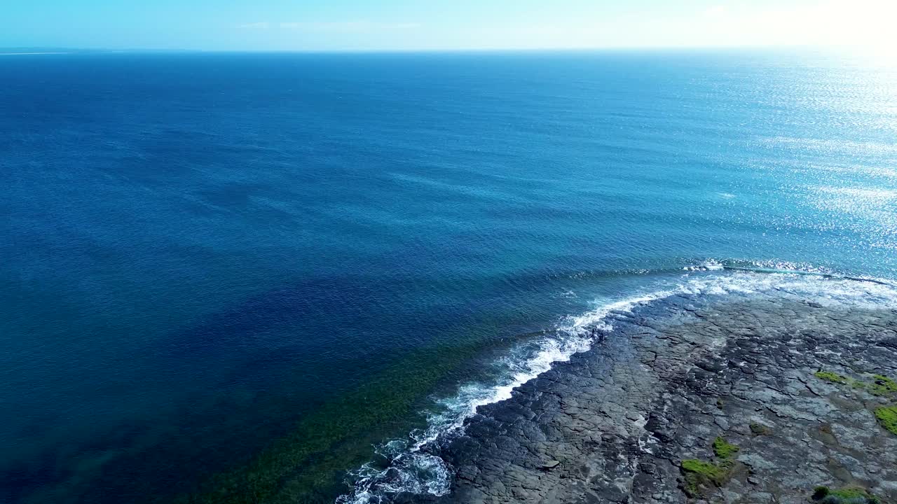 Drone aerial landscape Bawley Point headland ocean coastline horizon with waves breaking on rocky reef South Coast Shoalhaven Australia travel swimming tourism