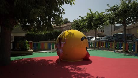 niño subiendo gran marco de escalada en forma de bola amarilla
