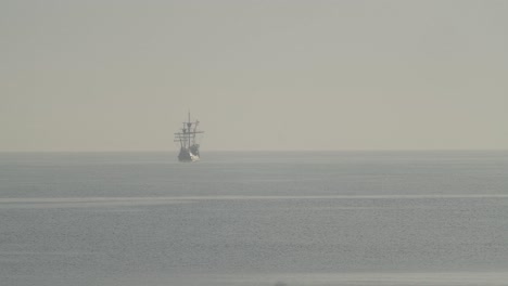 Ferdinand-Magallanes-Nao-Victoria-Carrack-Réplica-De-Barco-Con-Bandera-Española-Navega-En-La-Distancia-En-El-Mediterráneo-Al-Amanecer-En-Mar-Tranquilo-En-Cámara-Lenta-60fps