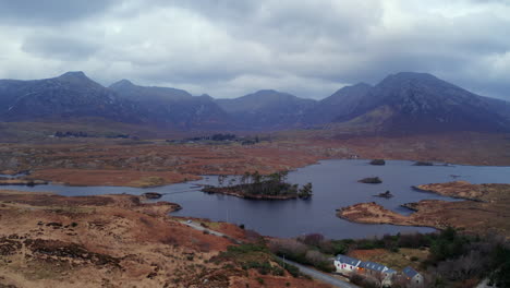 establishing aerial shot of connemara’s dramatic evening landscape, featuring pine island