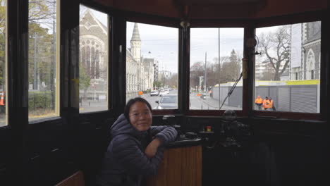female passenger inside traveling christchurch tram in christchurch, new zealand. closeup-medium shot