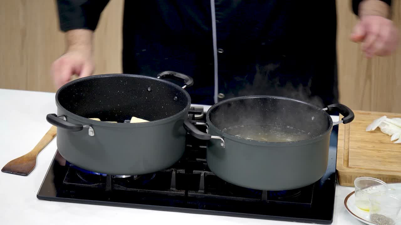 Chef prepares a savory pasta dish using two pots on the stove, featuring fresh ingredients and cooking techniques, showcasing culinary skills and efficiency.