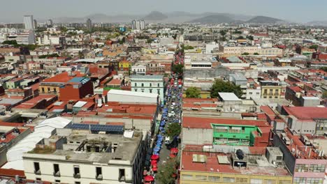 drone vuela sobre el mercado mexicano tradicional en la ciudad de méxico, bandera de méxico en primer plano