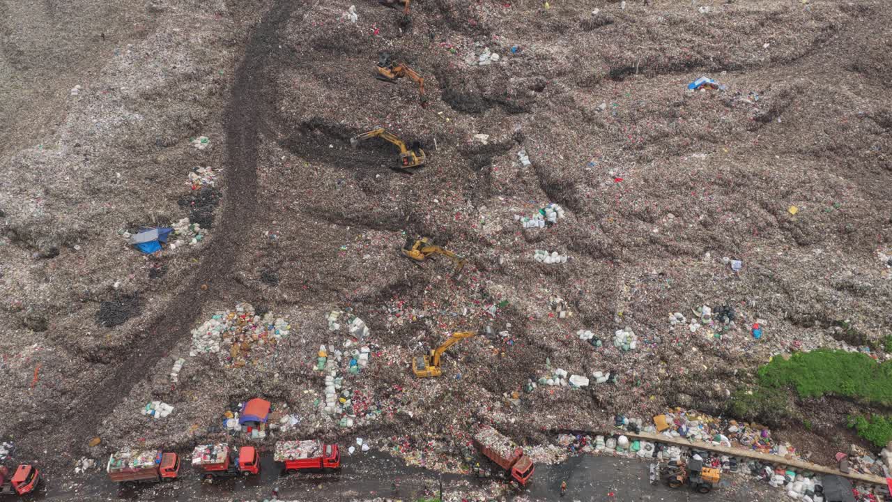 Aerial view of a massive landfill with trucks and excavators