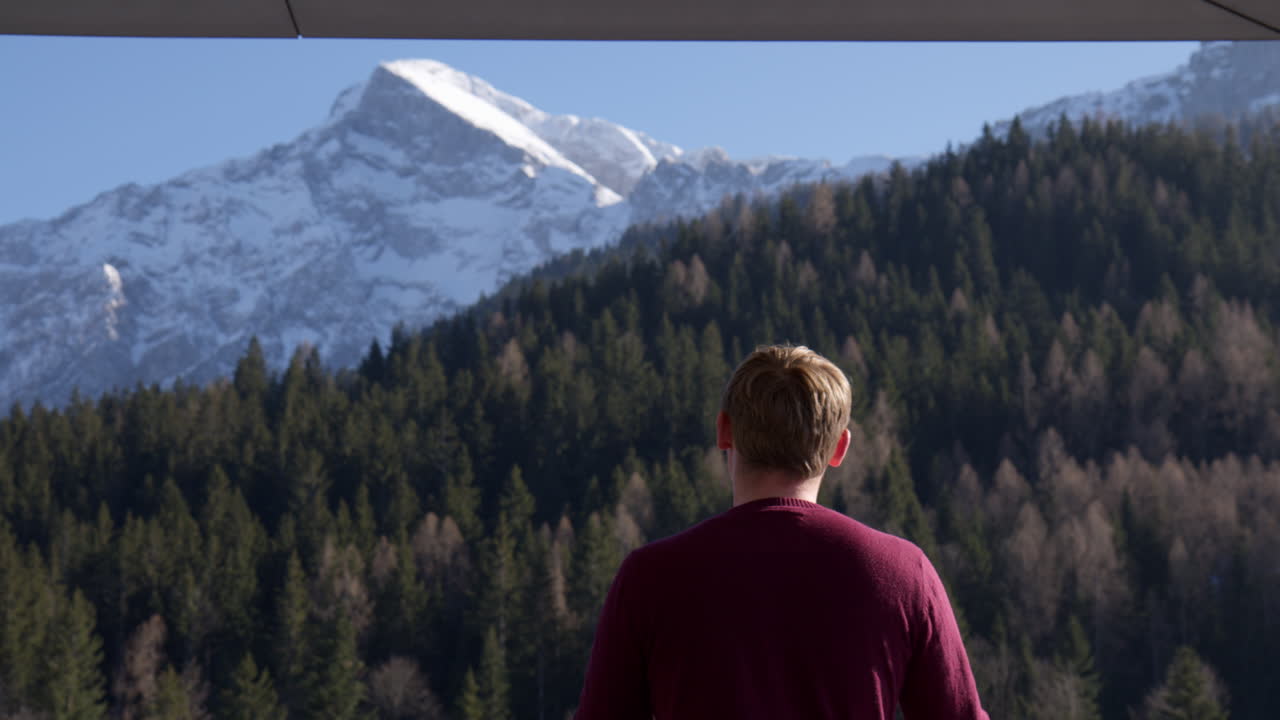 Rear Of A Man Looking At The Mountain Ridge Of Bavarian Alps In Germany. Sideways Shot