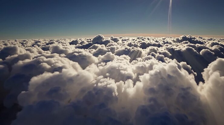 Aerial video view of fluffy clouds under a bright sun, capturing a serene and expansive sky