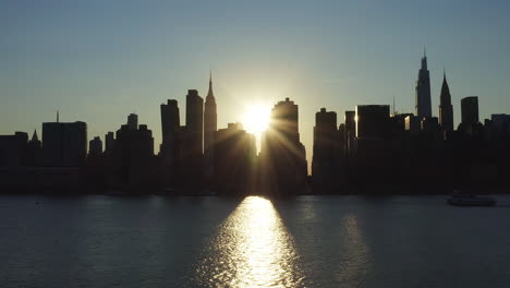 stationary shot at the beginning of the rare manhattanhenge phenomenon with an intense sunbeam shooting from between the buildings of the legendary skyline