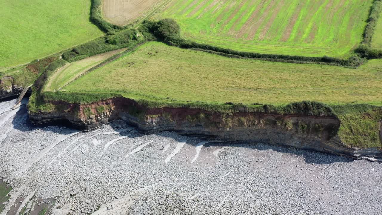 disparo de avión no tripulado mientras se mueve de izquierda a derecha sobre la playa de kilve y sus acantilados en north devon, reino unido