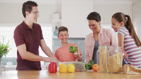 happy caucasian family unpacking bags with vegetables