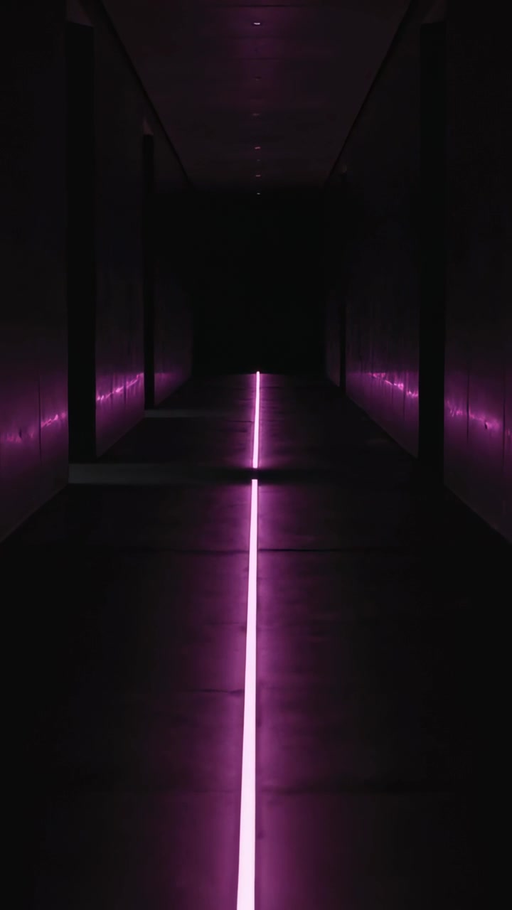 Video verticale: Telecamera che avanza mostrando una striscia LED magenta in un lungo corridoio, rivelando la sua estremità.