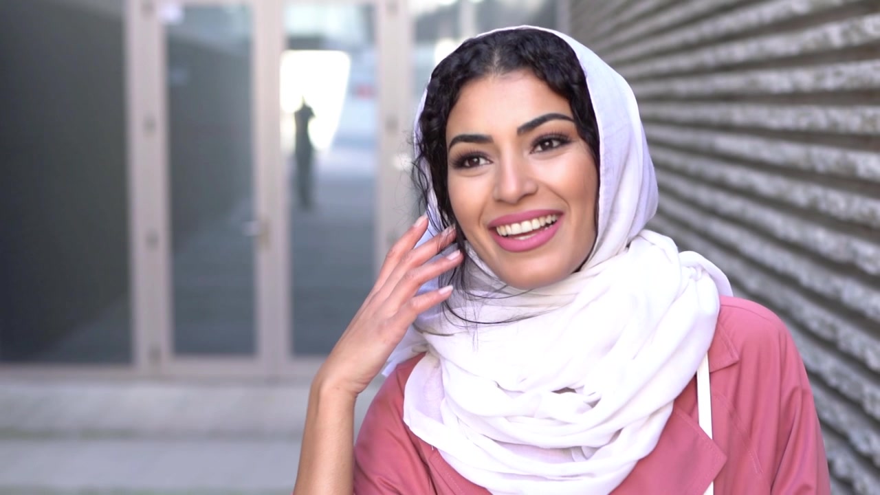 Joven mujer musulmana llevando un hiyab, caminando por el centro de la ciudad.