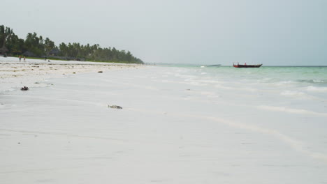 Ocean-waves-washing-tropical-white-sand-beach-in-Zanzibar,-Africa