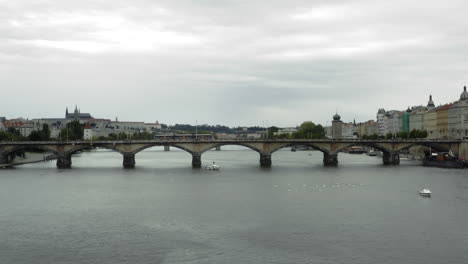 Aerial-push-in-of-tram-passing-on-Palacký-Bridge-in-Prague,-Czech-Rep