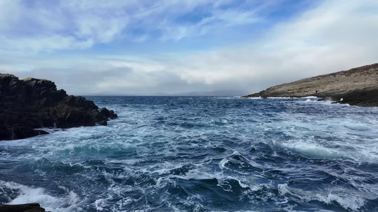 Irish Coast dramatic waves moody sky and churning waves crashing on beach west cork in winter
