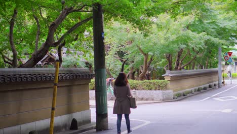 A-woman-walks-through-a-very-quiet-neighborhood-in-Tokyo,-this-area-is-surrounded-by-Buddhist-temples