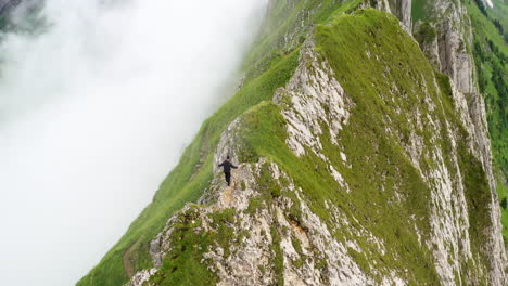 hiker walking on a mountain ridge in switzerland