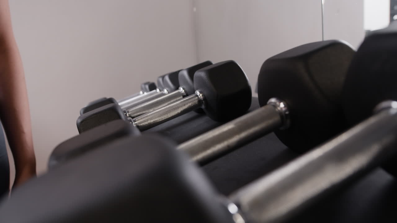 Persona che solleva dei manubri in una palestra