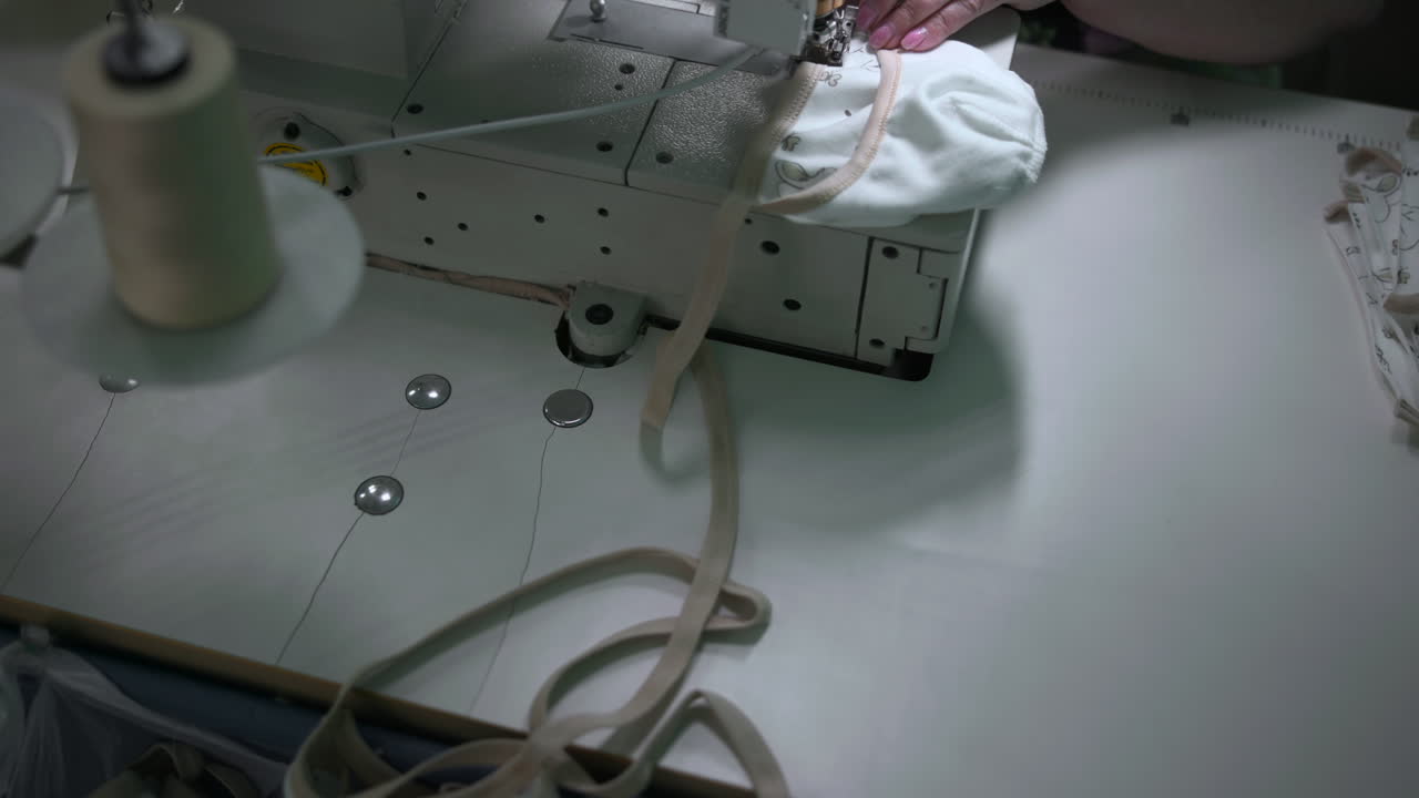 Industrial Sewing Machine Assembling Fabric Straps And Bindings, Operator Guiding Long Cords And Elastic. Media