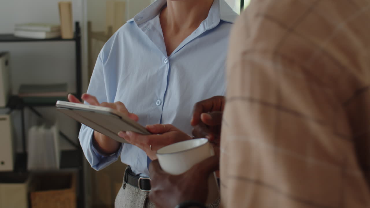 Young Employees Using Tablet Computer while Working at Office
