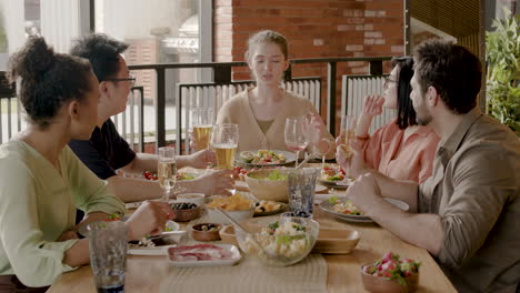 young female tells a story to her multicultural group of friends at a dinner party