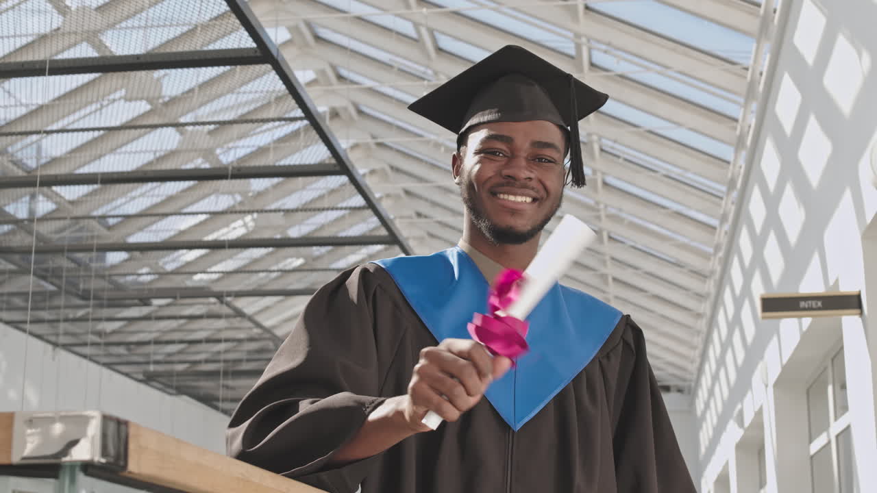 Portrait of Cheerful Male African-American Graduate in University