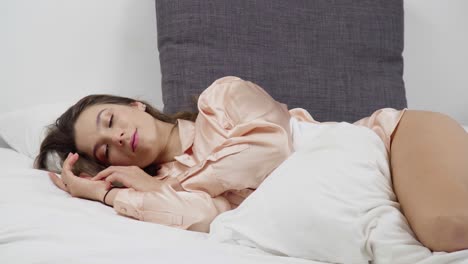 an attractive young woman comfortably lying on the bed