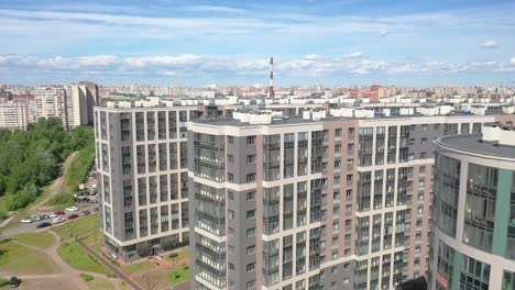 Aerial-Drone-Pull-Out-shot-of-a-residential-building-compound-next-to-the-Western-High-Speed-Diameter,-Gulf-of-Finland-in-Saint-Petersburg,-Russia