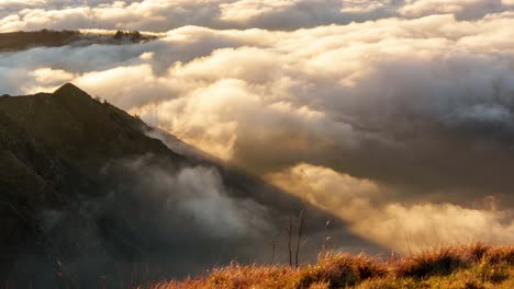 golden sunlight bathes mountain peaks piercing through a sea of clouds at sunset in genoa, liguria