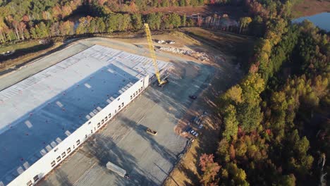 a-medium-orbiting-drone-shot-of-a-heavy-duty-crane-lifting-a-concrete-panel-into-place