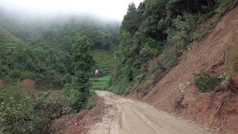 an empty muddy road in the foothills of the himalayas of nepal