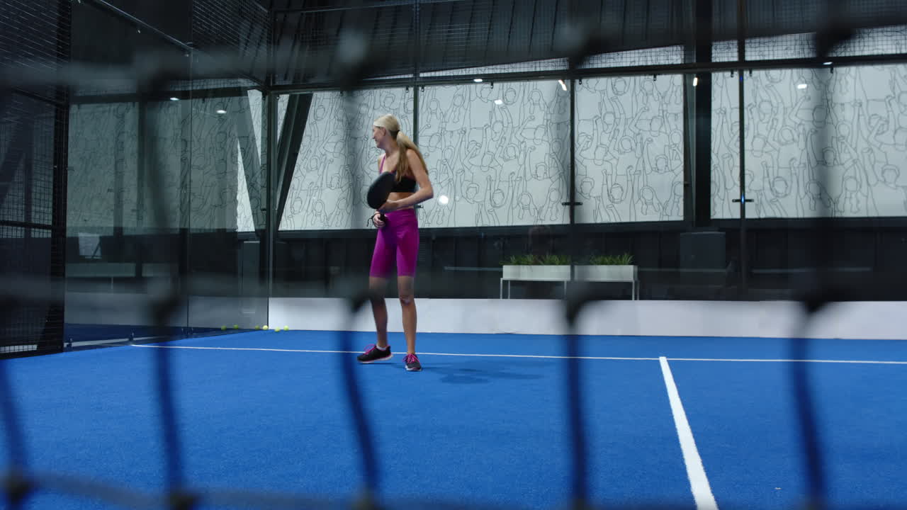 Playing padel tennis on indoor court, two athletes practicing on blue indoor court