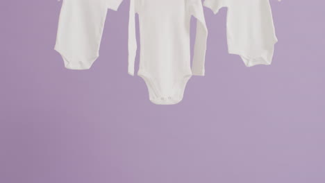 el video de primer plano de tres bebés blancos crecen colgando en un fondo púrpura.
