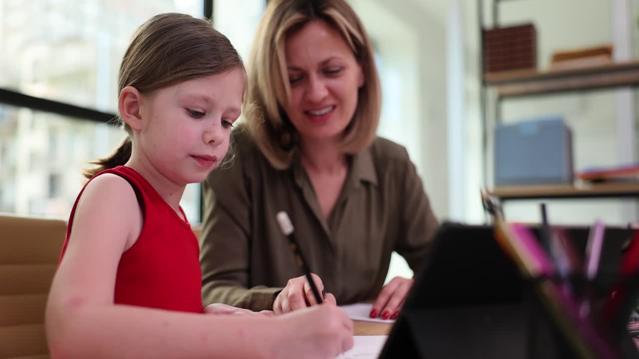 A young girl receiving tutoring from a woman