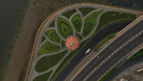 Parque-Diseñado-Con-Un-Patrón-De-Flor-De-Loto,-Río-Saigón,-Puente-De-Tráfico,-Canal-Y-Carretera-Principal-Girando-En-Sentido-Contrario-A-Las-Agujas-Del-Reloj-Desde-Un-Dron-De-Arriba-Hacia-Abajo