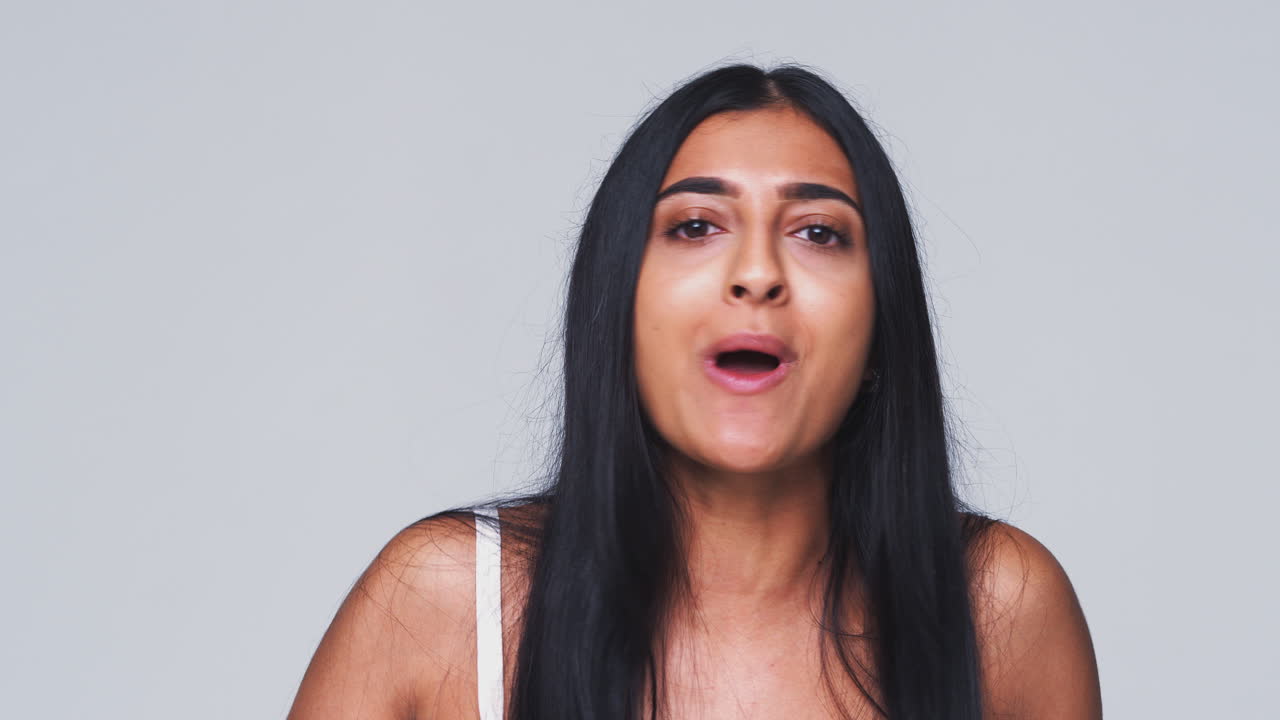Head And Shoulders Studio Shot Of Angry Woman Shouting At Camera In Slow Motion