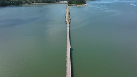 Toma-Aérea-De-Arriba-Hacia-Abajo-Del-Puente-Para-Bicicletas-Que-Cruza-La-Bahía-De-Fidalgo