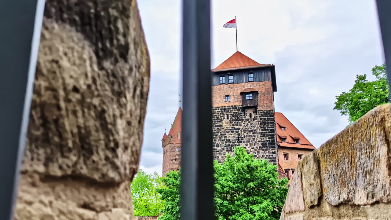 Historic Fünfeckturm Castle Tower in Nurnberg framed by bars and stone wall
